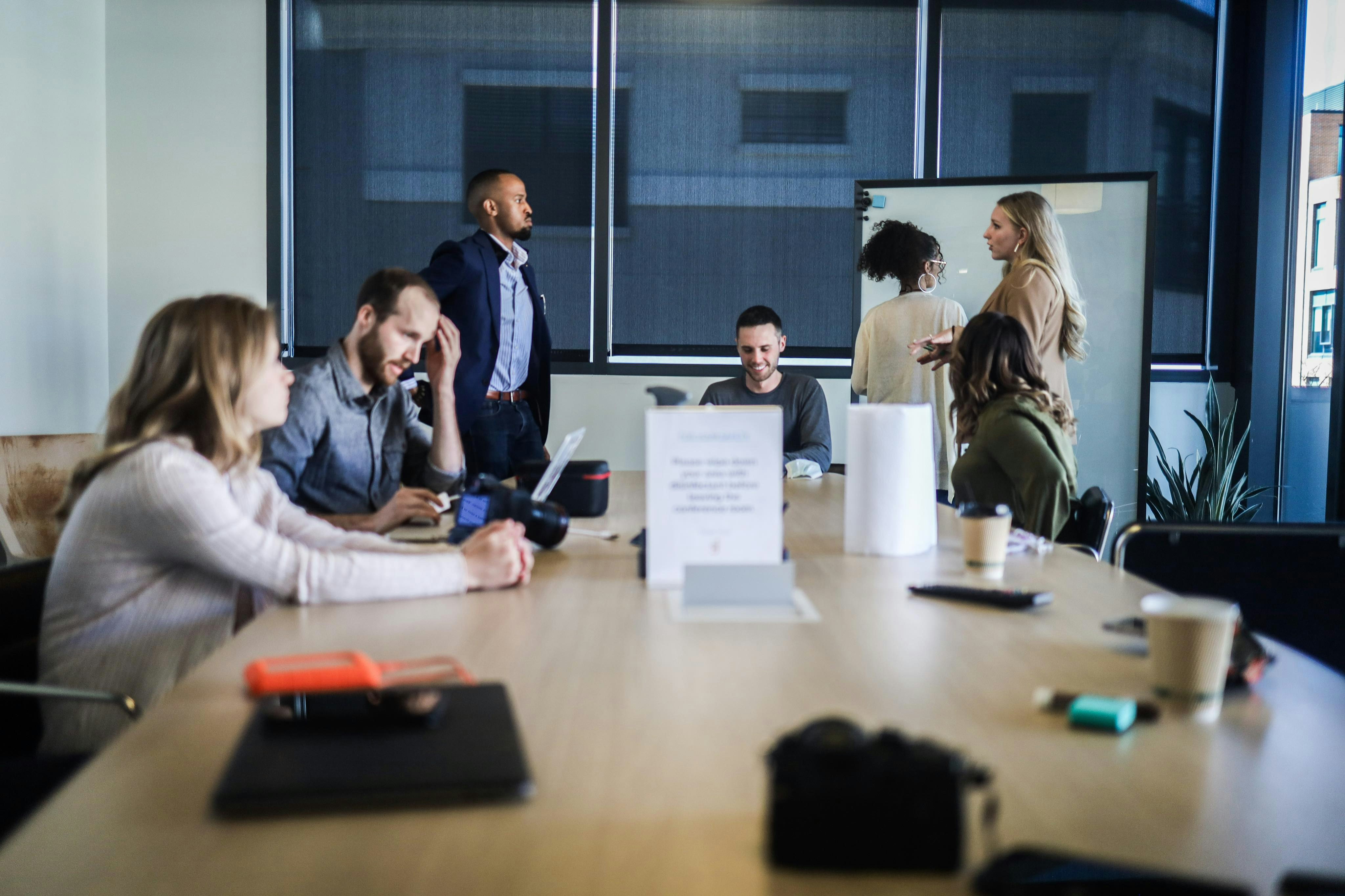 An image of a group of people having a meeting in a boardroom discussing SEO strategy